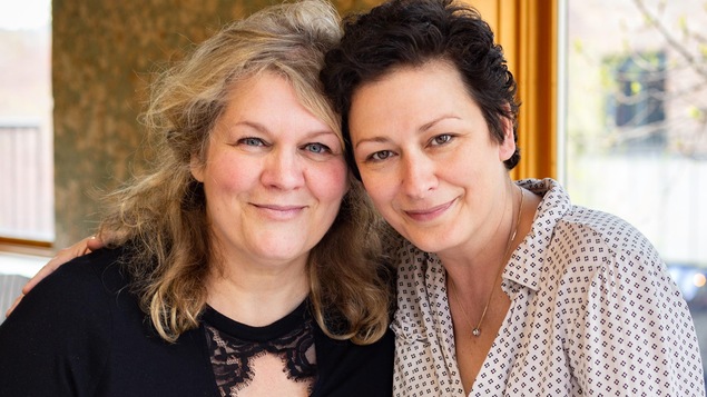 Les deux femmes posent côte-à-côte, dans un restaurant.