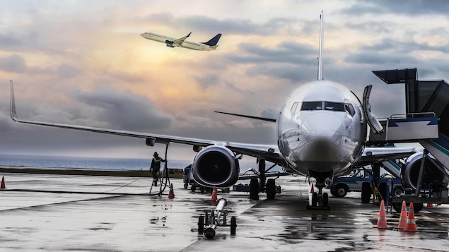 Photo d'un avion sur le tarmac d'un aéroport et d'un autre qui décolle.