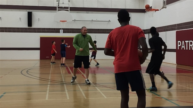 Des élèves jouent au basketball dans un gymnase.