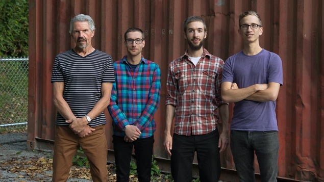 Les quatre membres du groupe Early Spirit posent devant un conteneur
