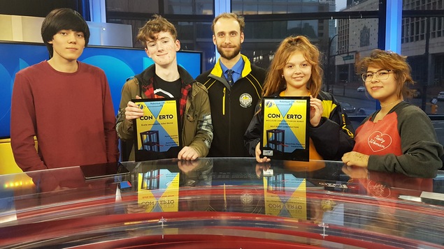 Une photo dans les studios de Radio-Canada à Vancouver du directeur adjoint de l'école secondaire Jules Verne, avec les quatre élèves qui ont participé à une compétition de robotique à Montréal