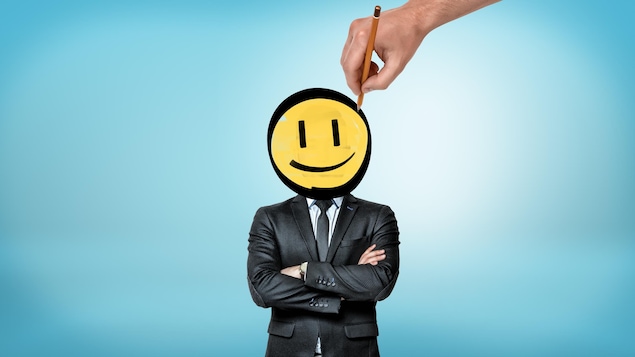 Un homme d'affaires dont la tête est redessinée pour ressembler à un « bonhomme sourire ».