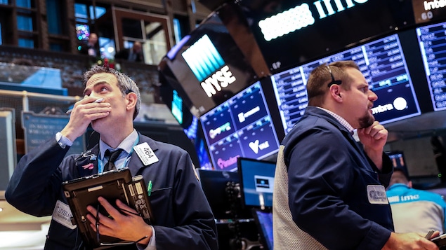 Des employés de la Bourse de New York observent leurs écrans avec inquiétude.