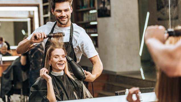 Un coiffeur passe du bon temps avec une cliente.