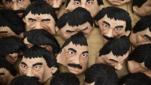 Des masques à l'effigie du narcotrafiquant Joaquin Guzman Loera, alias El Chapo, accrochés au mur.