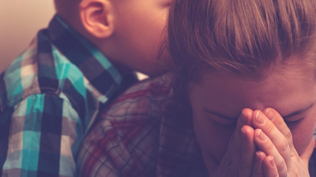 Un enfant étreint sa mère pendant qu'elle pleure.