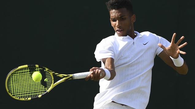 Félix Auger-Aliassime en action sur un court de tennis.