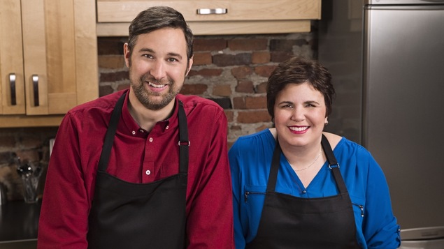 Les deux animateurs sourient à la caméra avec leur tablier de chef.