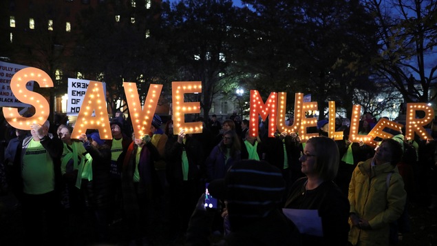 Des manifestants tiennent des lettres illuminées pour afficher le slogan « Save Mueller ».