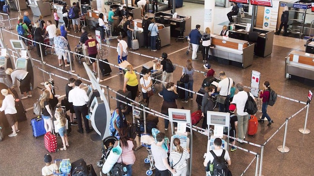 Des passagers s'enregistre dans un aéroport
