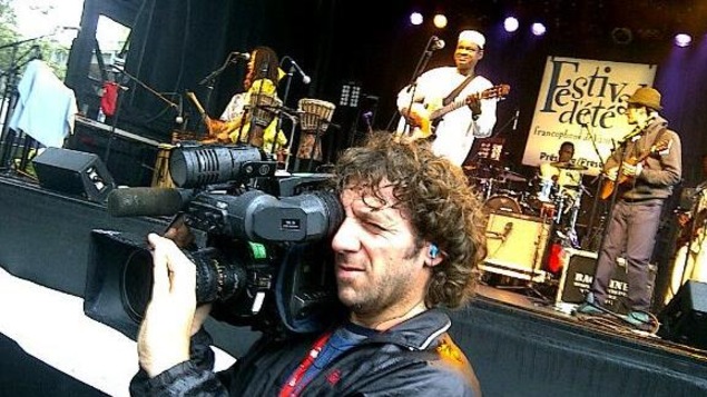 Daniel Beauparlant, caméra à l'épaule, devant la scène extérieure du Festival d'été de Vancouver.