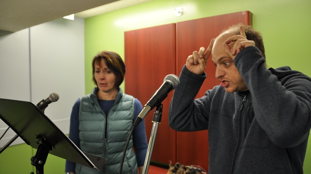 2 personnes sont devant un micro de radio.