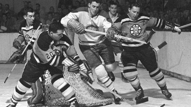 Un joueur du Canadien tente d'atteindre la rondelle derrière le but des Bruins de Boston, en 1958.
