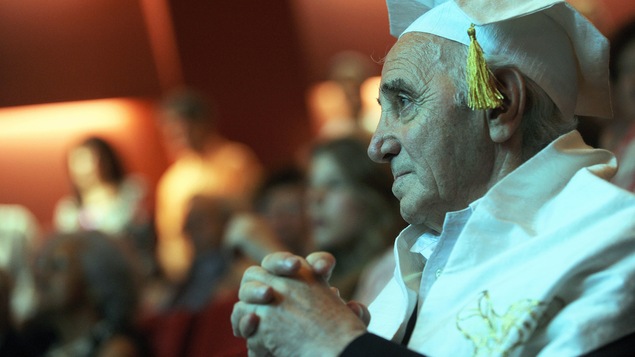 Charles Aznavour en tenue de finissant le regard tourné vers la gauche