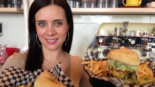 La jeune femme tient deux plats dans ses mains.