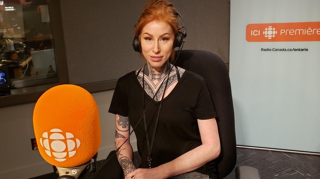 Une femme tatouée devant un micro de Radio-Canada.
