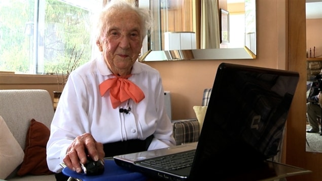 Claire Sigouin, centenaire coquette et bien active, devant son ordinateur.