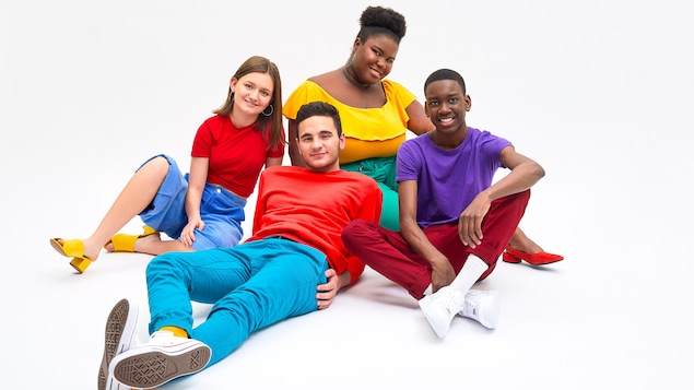 Quatre adolescents rassemblés portant des vêtements très colorés
