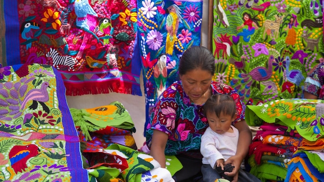 Une femme et une enfant entouré de tissus colorés.