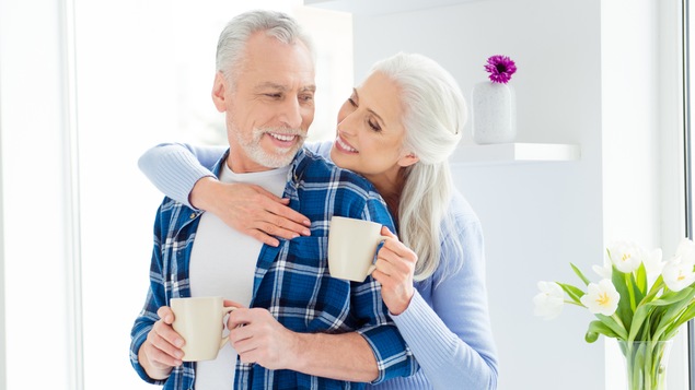Un couple boit du café dans leur cuisine.