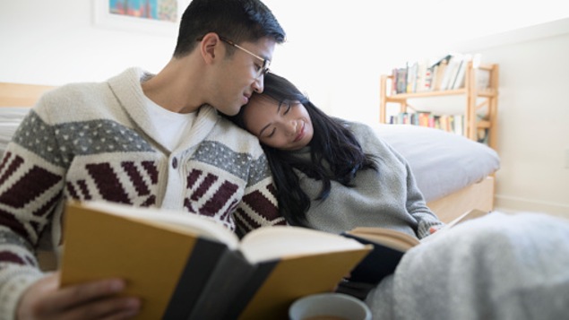 Deux amoureux lisent des livres et boivent du café dans leur chambre.