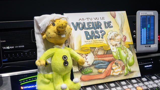 Le livre « As-tu vu le voleur de bas ? » du Dr. Yannick Charette, avec illustrations de Monique Legault avec une poupée d'un lutin, un des personnages principaux.