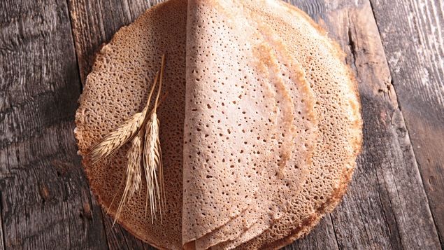 Quelques crêpes sont posées sur une table de bois