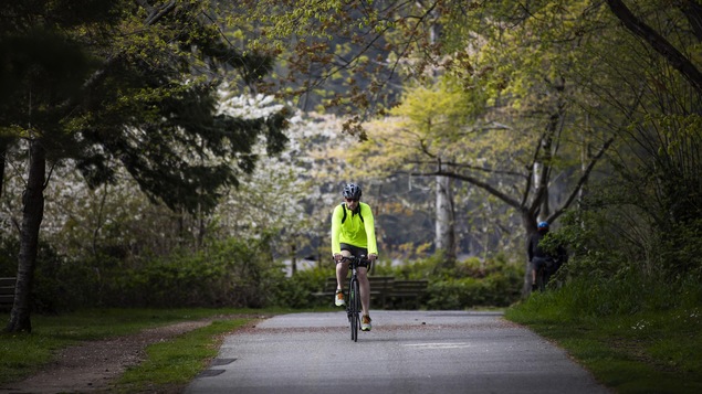 Un cycliste au coeur du Parc Stanley, à Vancouver.