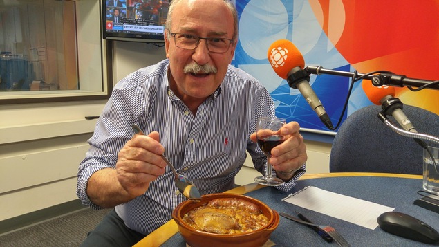 Daniel Pachon avec un Cassoulet et un verre de vin en studio.