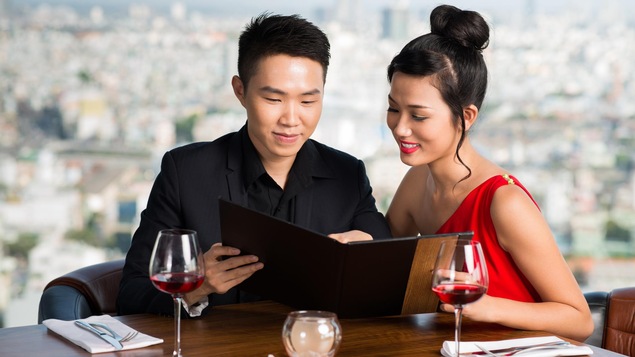 Un couple hétérosexuel de Vietnamiens lisant un menu.