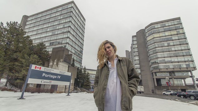 Jeune femme en face des bureaux du Gouvernement du Canada