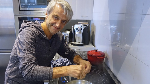 jean Soulard émiette du cannabis lors de la préparation d'un repas