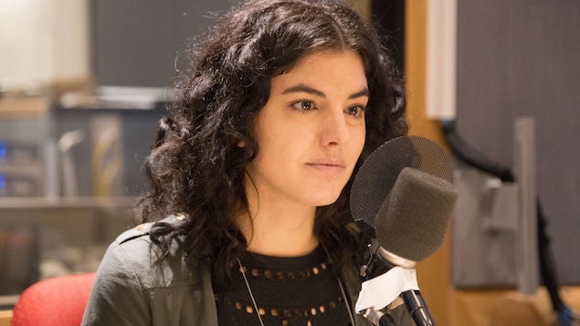 Karine Péloffy, assise derrière un micro