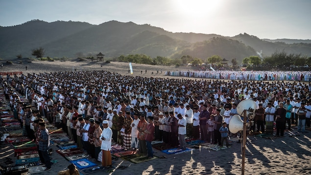 Des musulmans indonésiens exécutent une prière lors de la célébration de Eid Al-Fitr sur la plage de Parangkusumo dans la région de Yogyakarta, sur l'île de Java en Indonésie.