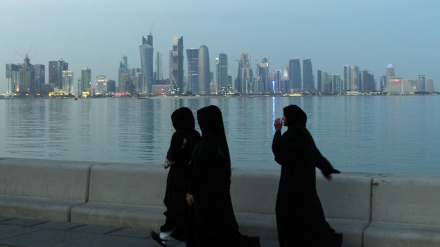 Trois femmes marchent à Doha, capitale du Qatar.