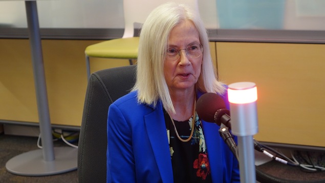 La directrice du festival Frye Diana Newton assise et parlant au micro de l'émission Le Réveil Nouveau-Brunswick