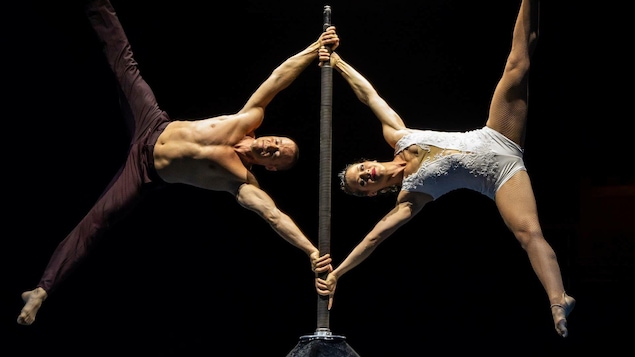 Un homme et une femme qui se tiennent à l'horizontal sur une perche verticale.