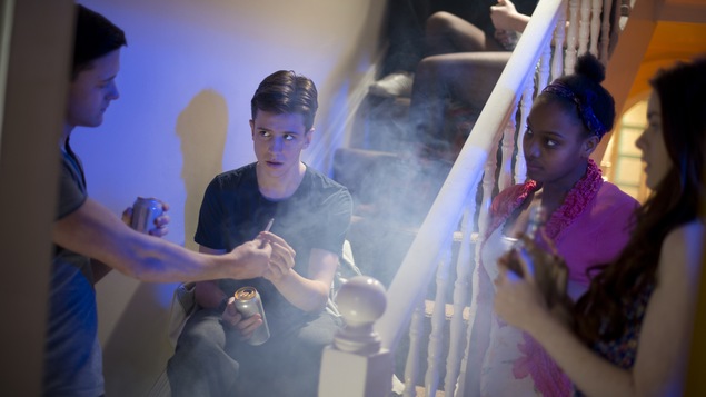 Des jeunes fument un joint dans une fête.