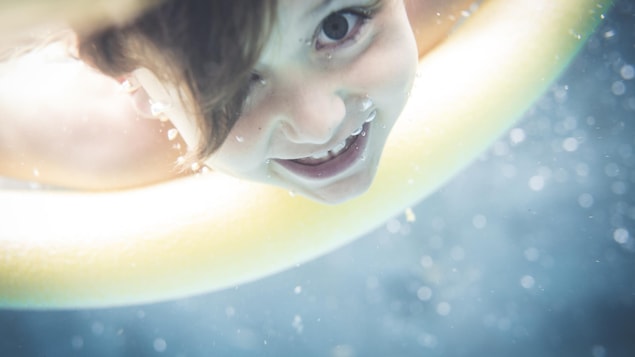 Un enfant se baigne dans une piscine.