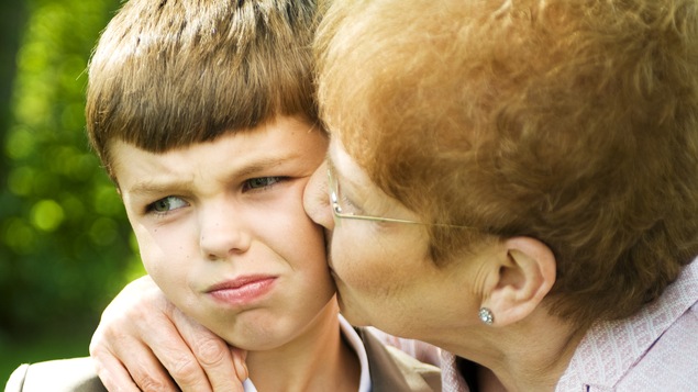 Un garçon qui n'aime pas se faire embrasser par sa grand-mère.