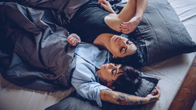Deux personnes dans un lit sommeillent.