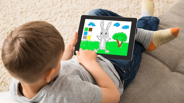 Un enfant joue avec une tablette.