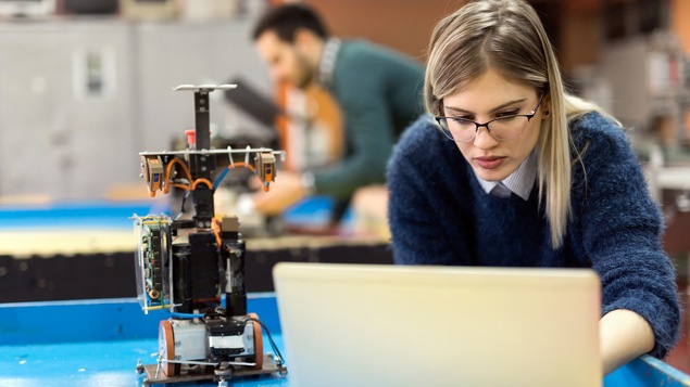 Une femme dans une classe de robotique.