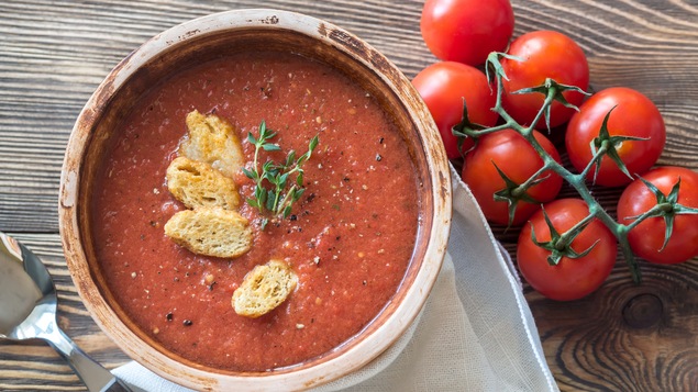 Un bol de gaspacho déposé sur une table.