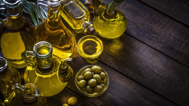 Des bouteilles d'huile d'olive disposées sur une table.