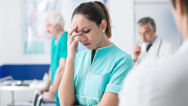 Une infirmière semble épuisée par son travail.