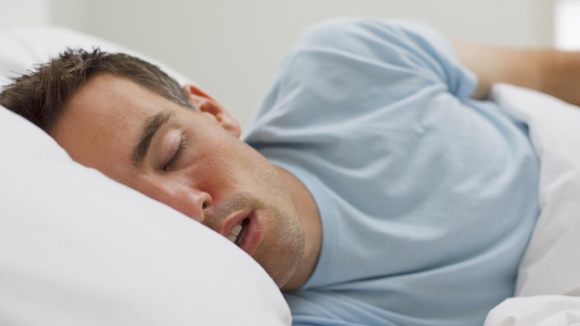 Un homme dort dans son lit.