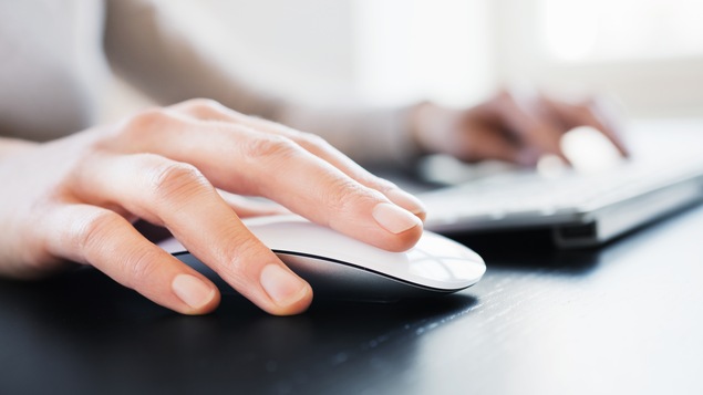 Un homme utilise un ordinateur au bureau.