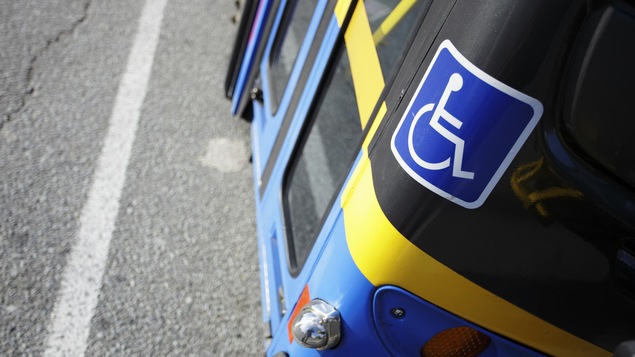 Une vignette posée sur un autobus indiquant que le véhicule est accessible aux personnes handicapées.