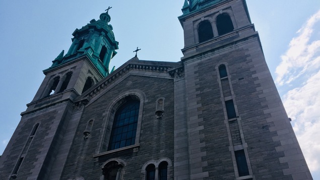 Une grande église en pierre à deux clochers.